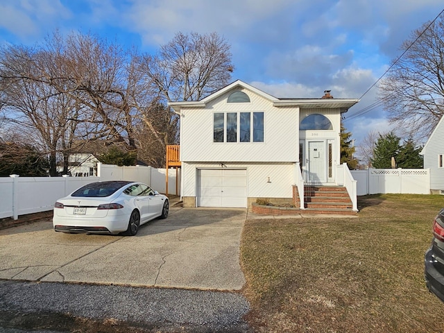 bi-level home featuring a garage and a front lawn