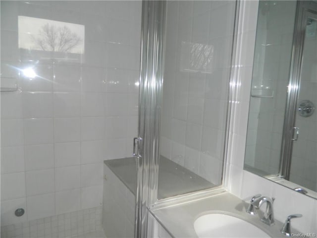 bathroom with a shower with door and vanity