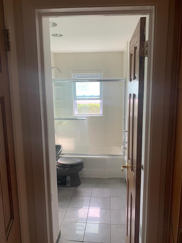 bathroom featuring toilet, tile patterned flooring, and washtub / shower combination