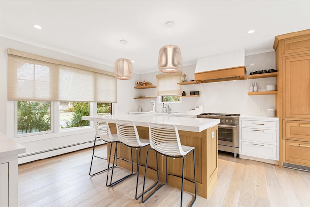 kitchen featuring decorative light fixtures, a baseboard heating unit, a center island, stainless steel stove, and white cabinets