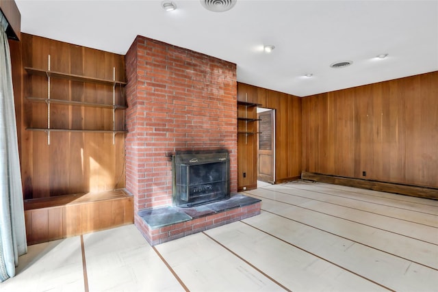 unfurnished living room with a brick fireplace and wooden walls