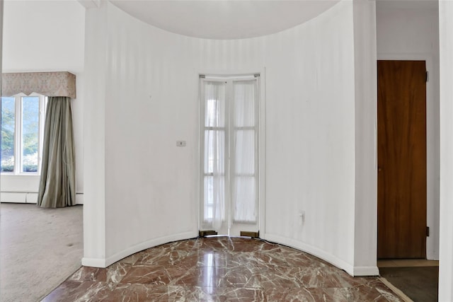 carpeted empty room featuring a baseboard radiator