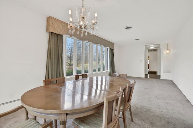 carpeted dining area featuring a chandelier