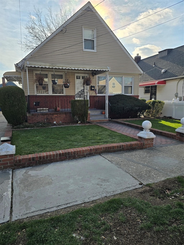 bungalow-style house with covered porch and a yard