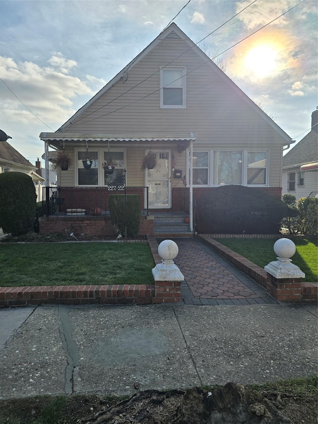 view of front of home featuring covered porch and a lawn