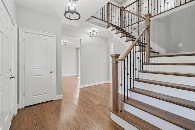 stairs with a chandelier and hardwood / wood-style flooring