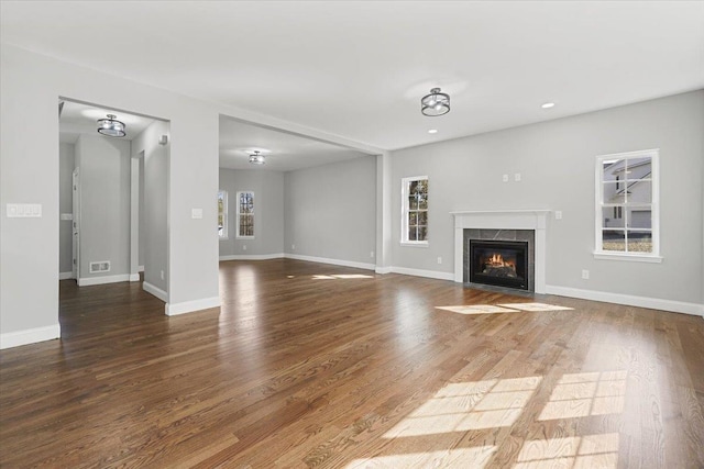 unfurnished living room with dark hardwood / wood-style flooring and a premium fireplace