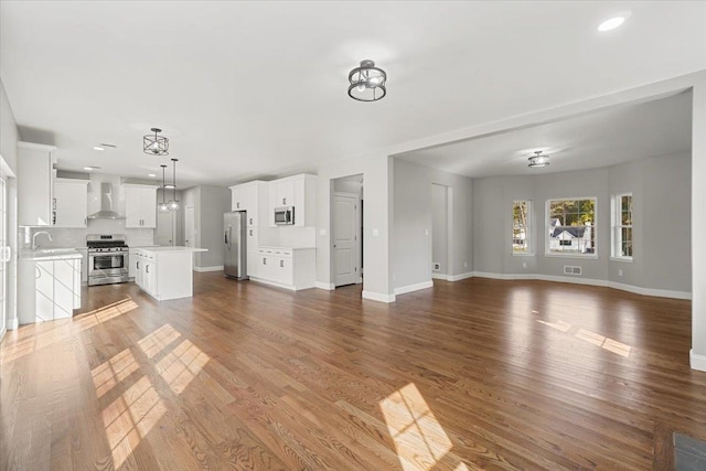 unfurnished living room featuring sink and hardwood / wood-style floors