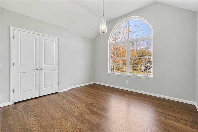 empty room with hardwood / wood-style flooring and lofted ceiling