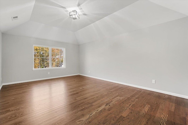 spare room featuring hardwood / wood-style floors and vaulted ceiling