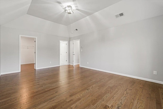 unfurnished room with vaulted ceiling and dark hardwood / wood-style floors