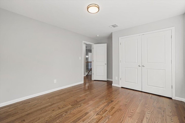 unfurnished bedroom featuring wood-type flooring and a closet