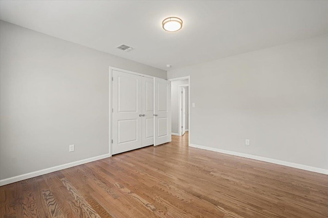 unfurnished bedroom featuring a closet and light wood-type flooring