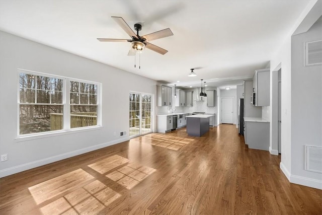 unfurnished living room featuring hardwood / wood-style floors and ceiling fan