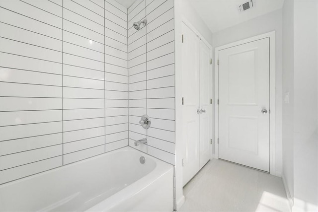 bathroom with tile patterned flooring and tiled shower / bath