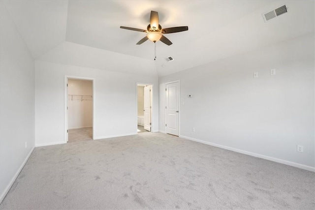 unfurnished bedroom featuring ceiling fan, a closet, light colored carpet, and a spacious closet