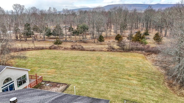 view of yard featuring a deck with mountain view