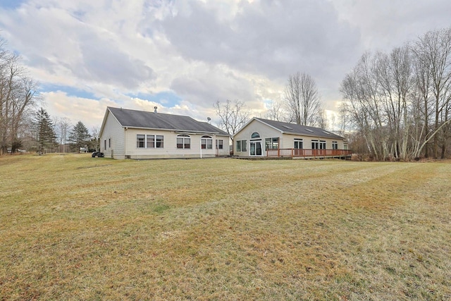 view of front facade with a wooden deck and a front yard