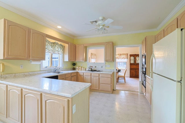 kitchen featuring kitchen peninsula, appliances with stainless steel finishes, light brown cabinetry, ceiling fan, and sink