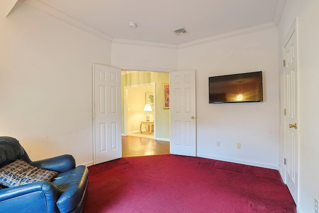 sitting room with ornamental molding and carpet floors