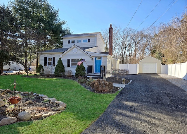 front of property featuring a front yard, a garage, and an outdoor structure