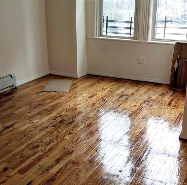 spare room with hardwood / wood-style flooring and baseboard heating