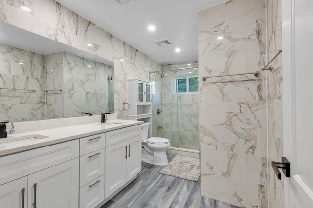 bathroom featuring hardwood / wood-style floors, vanity, tile walls, toilet, and walk in shower