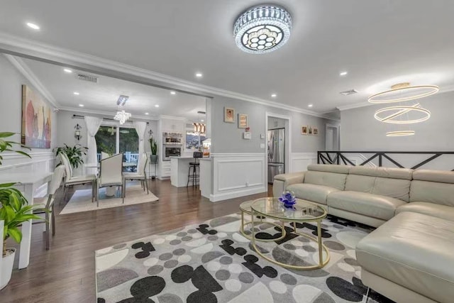 living room featuring a chandelier, crown molding, and dark hardwood / wood-style flooring