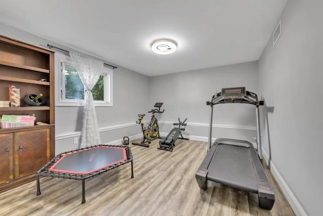 exercise room featuring light wood-type flooring