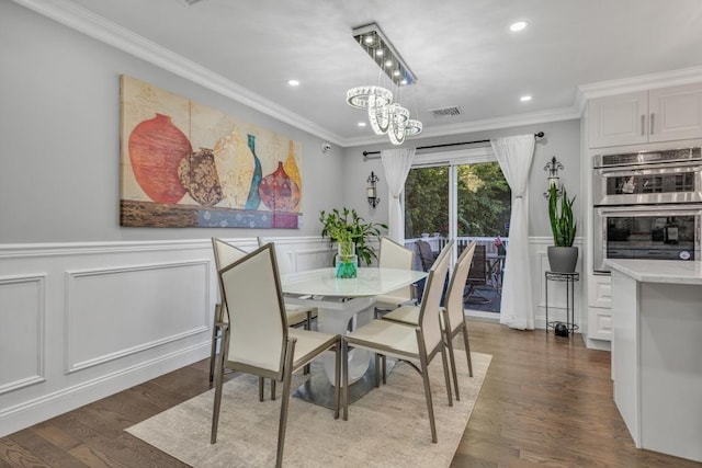 dining area with dark hardwood / wood-style floors, crown molding, and a chandelier