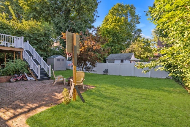 view of yard featuring a wooden deck and a storage unit