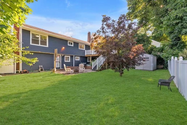 back of property with a storage shed, a lawn, and a patio