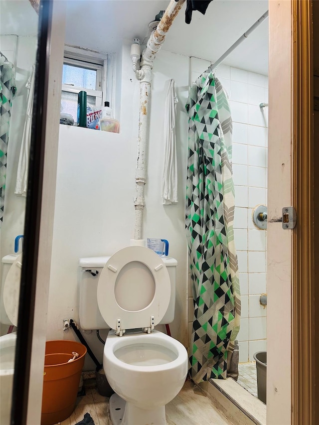 bathroom featuring toilet and a shower with shower curtain