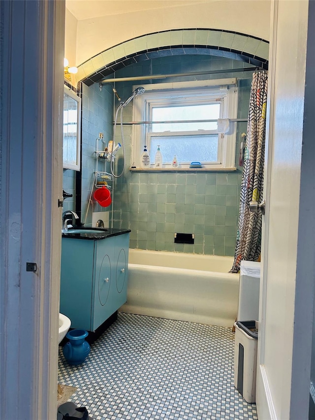 bathroom with vanity, shower / tub combo with curtain, and a healthy amount of sunlight