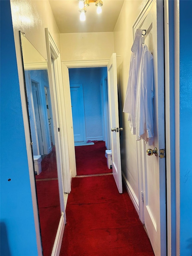 hallway featuring dark colored carpet