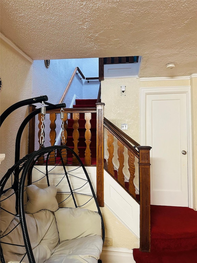 stairway featuring a textured ceiling