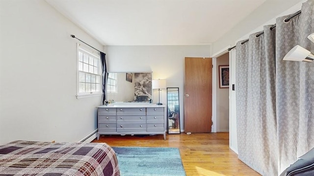 bedroom featuring hardwood / wood-style floors and a baseboard radiator