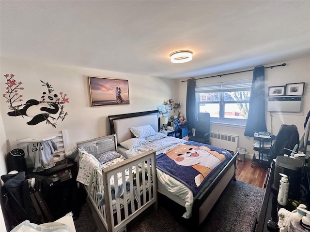 bedroom with dark hardwood / wood-style flooring and radiator