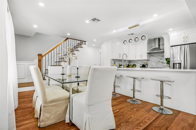 dining space featuring wood-type flooring and sink