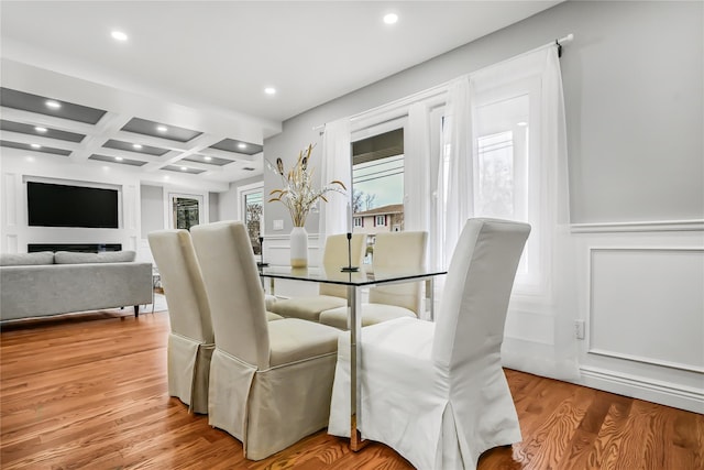 dining space featuring beamed ceiling, light hardwood / wood-style floors, and coffered ceiling