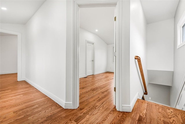 corridor featuring vaulted ceiling and light hardwood / wood-style flooring