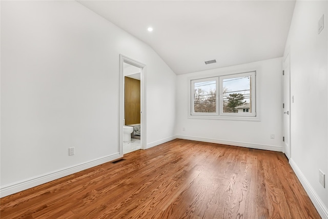 empty room with light hardwood / wood-style floors and lofted ceiling