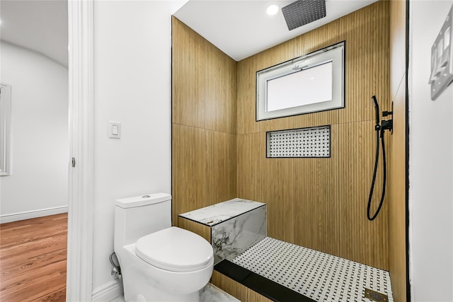 bathroom featuring a shower, hardwood / wood-style flooring, and toilet