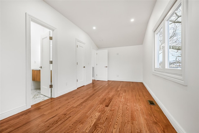 bonus room with lofted ceiling and light wood-type flooring