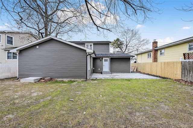 back of property with a lawn and a patio area