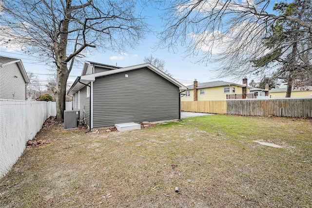 back of house with a lawn and central air condition unit