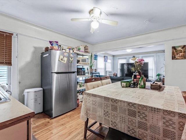 dining area with light wood-type flooring and ceiling fan