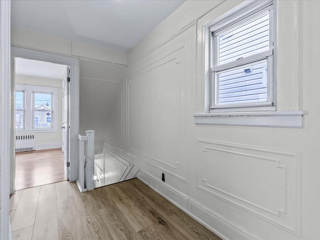 interior space with radiator heating unit and light hardwood / wood-style floors