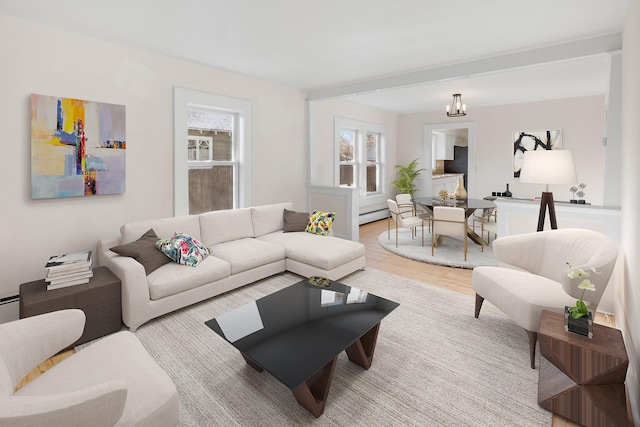 living room with light wood-type flooring, a notable chandelier, a baseboard radiator, and plenty of natural light