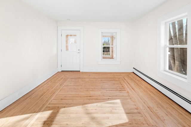 spare room featuring light wood-type flooring and baseboard heating